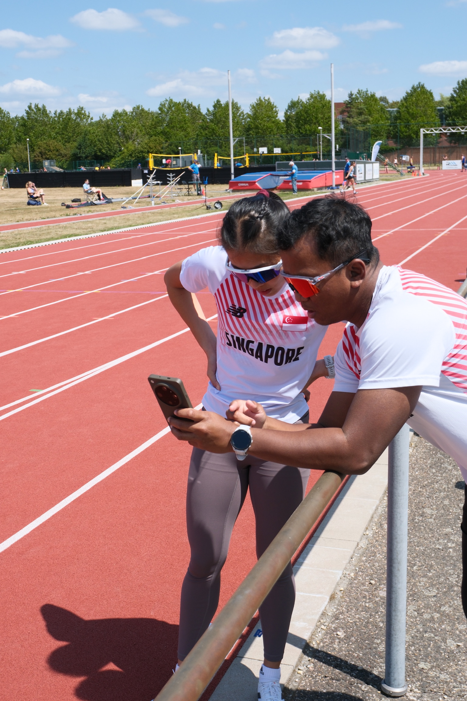 Coach Khai reviewing splits with an athlete trackside
